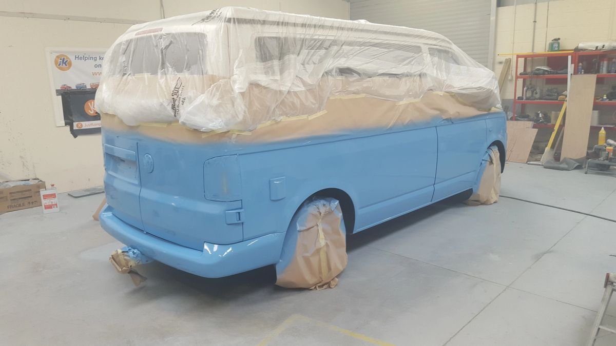 A masked Volkswagen van with freshly painted blue bodywork
