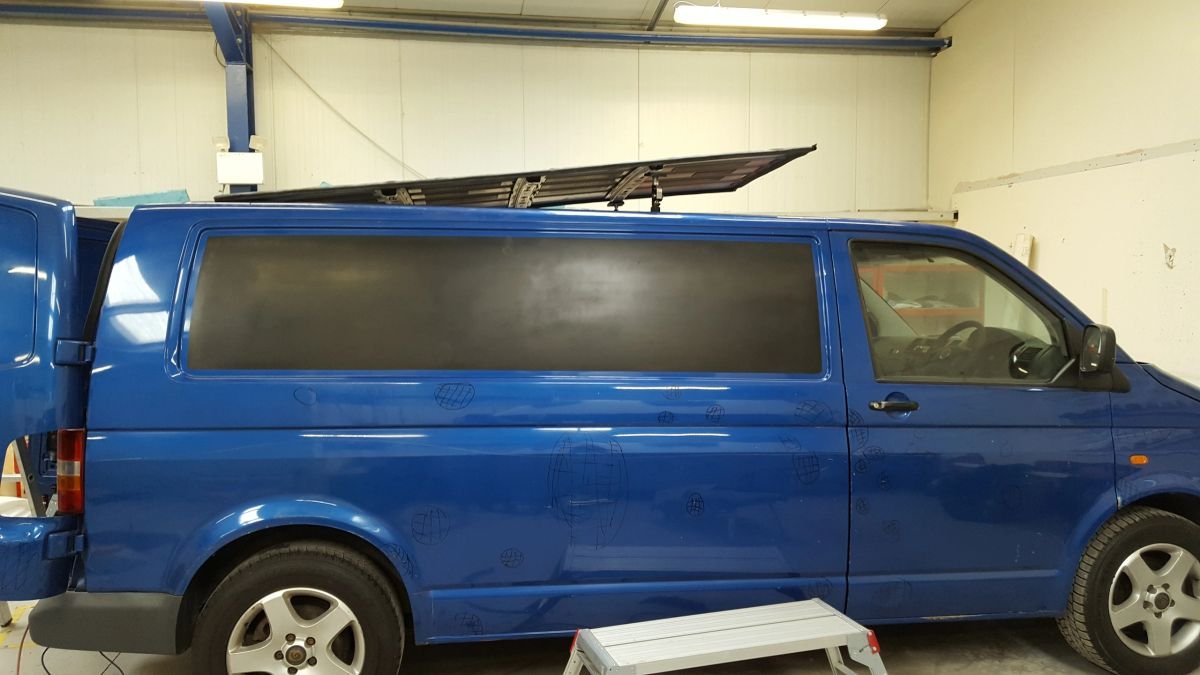 A blue campervan with side window fitted
