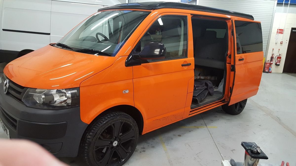 An orange campervan with its sliding door open
